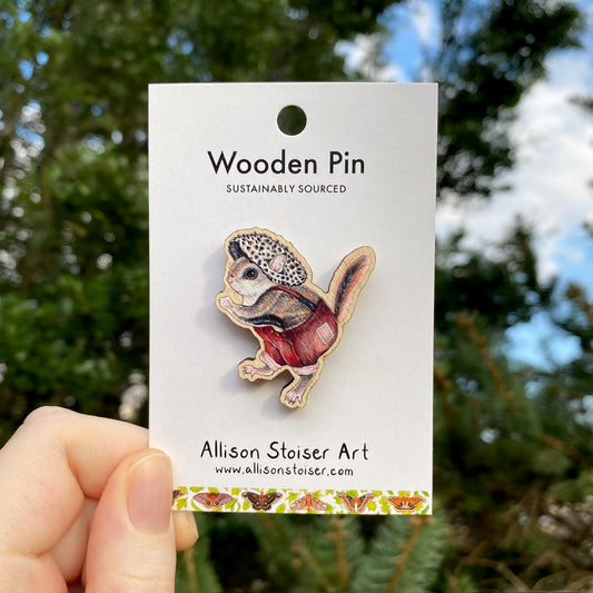 A wooden pin of a flying squirrel in a mushroom hat