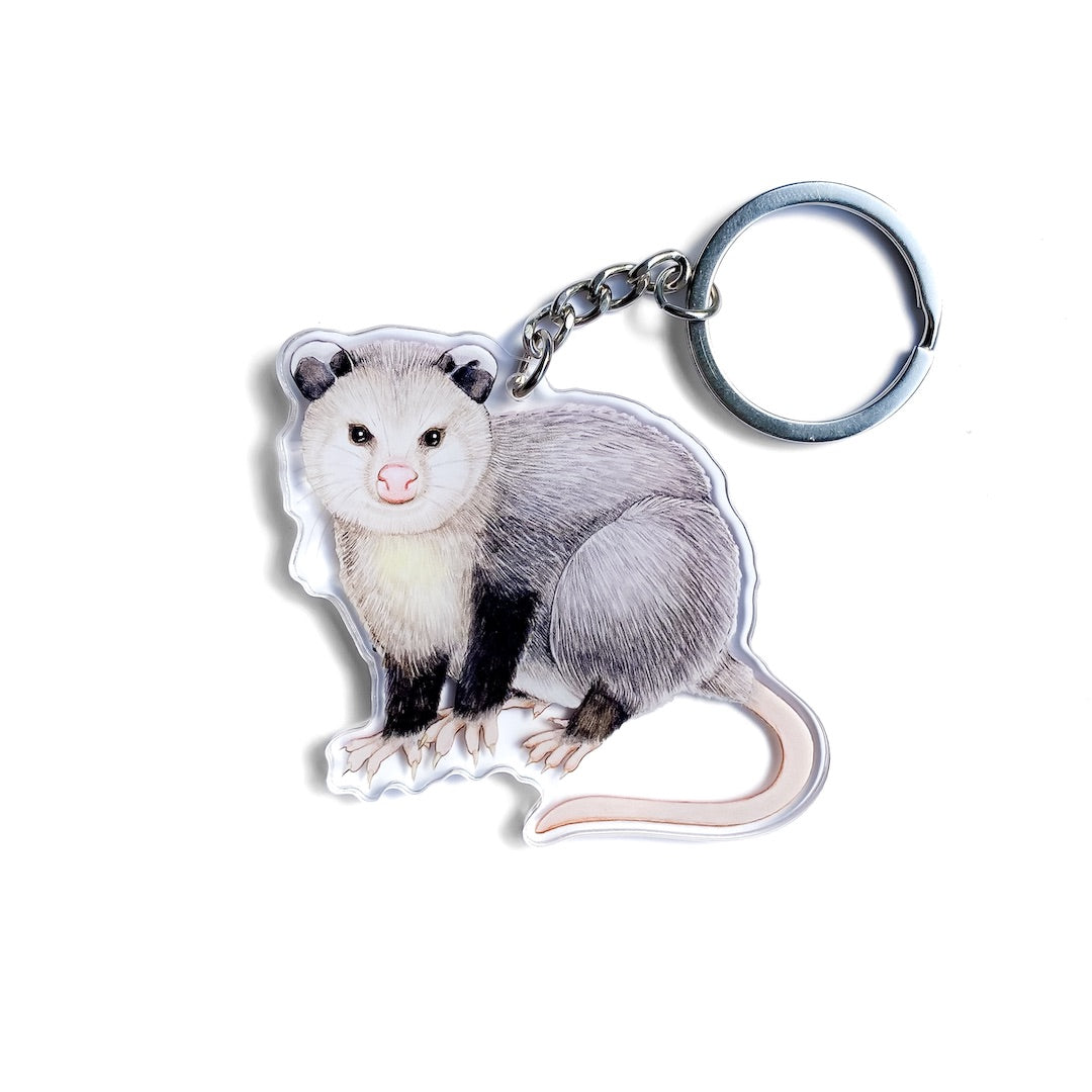 A keychain of a Virginia opossum on a white background.