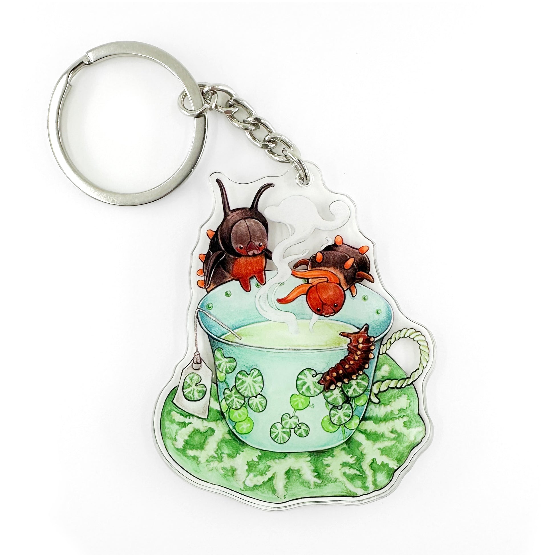 A keychain featuring an illustration of a pipevine swallowtail caterpillar tea party