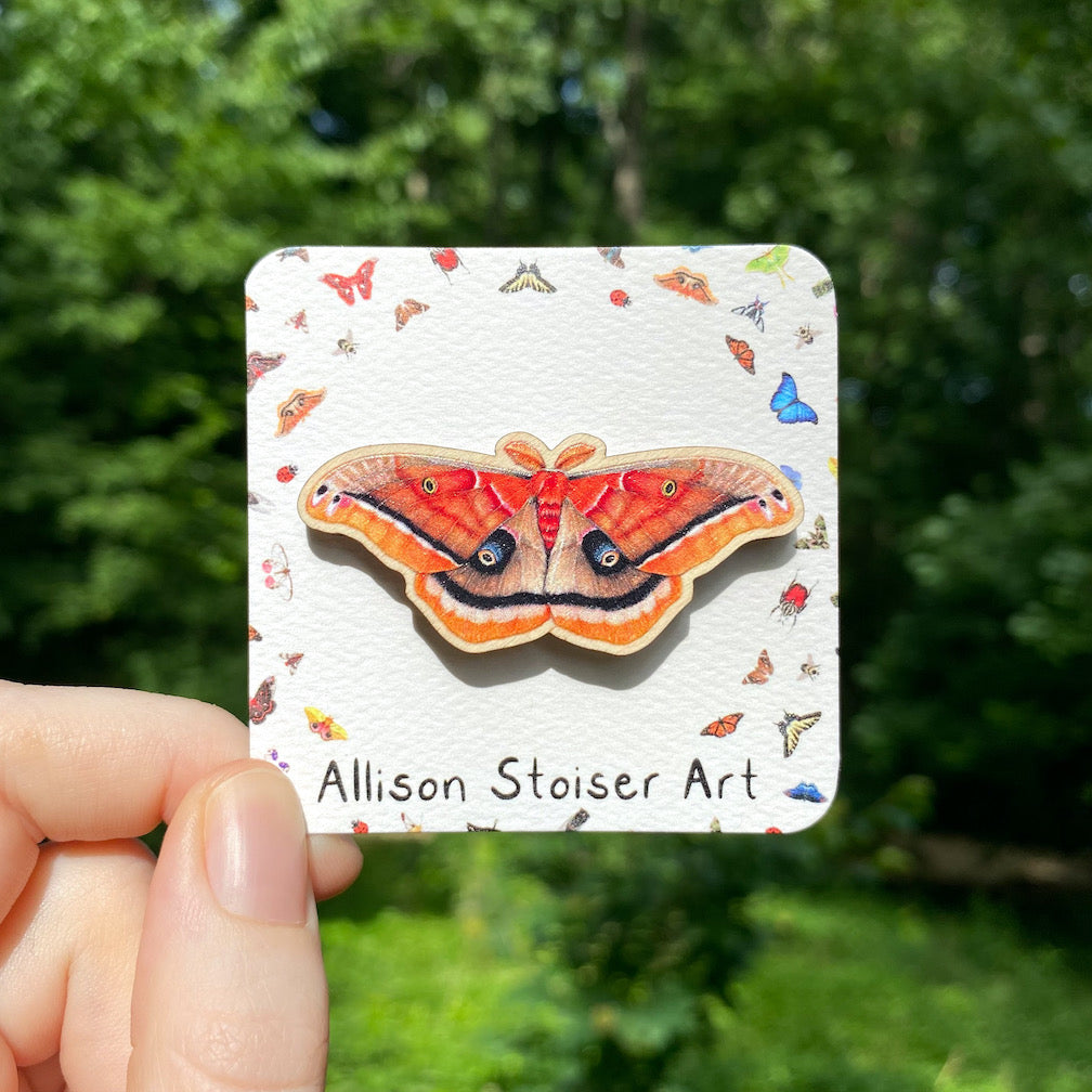 A sustainably sourced pin featuring an illustration of a Polyphemus moth