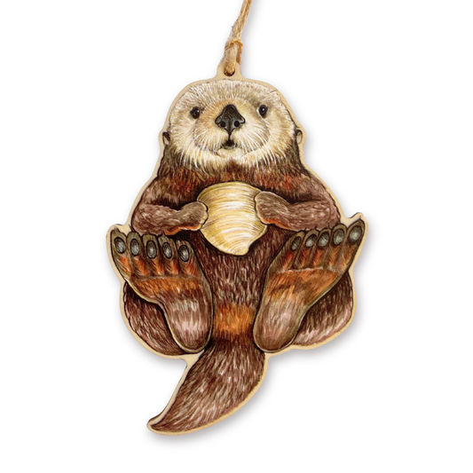 Wooden ornament of a sea otter holding a shell on a white background
