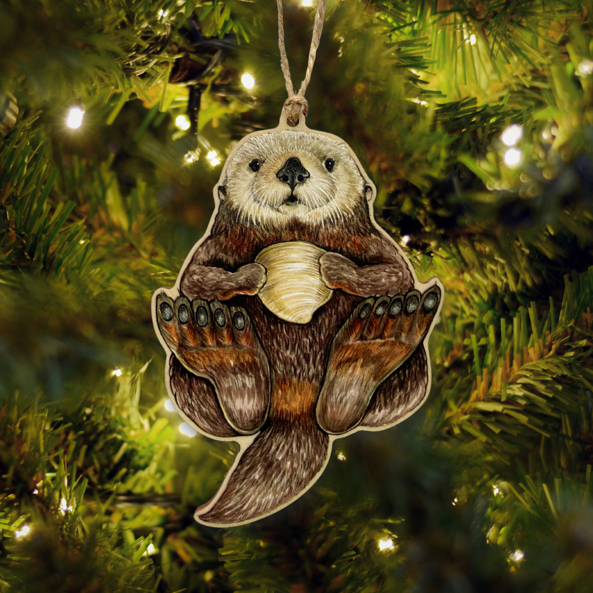 Ornament of a sea otter holding a clam on a Christmas tree.