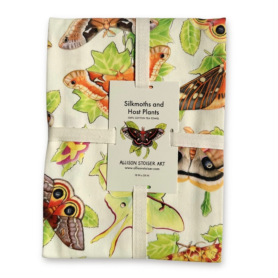 A ribbon-wrapped tea towel featuring moths on their host plants