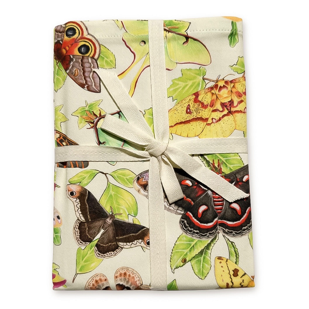 A ribbon-wrapped tea towel featuring moths on their host plants