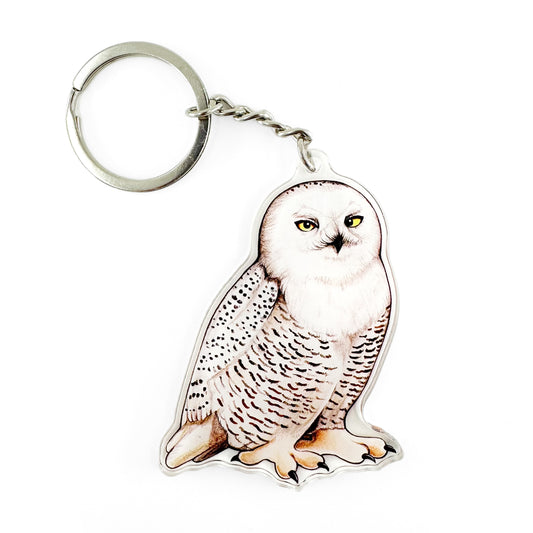 A keychain of a snowy owl on a white background.