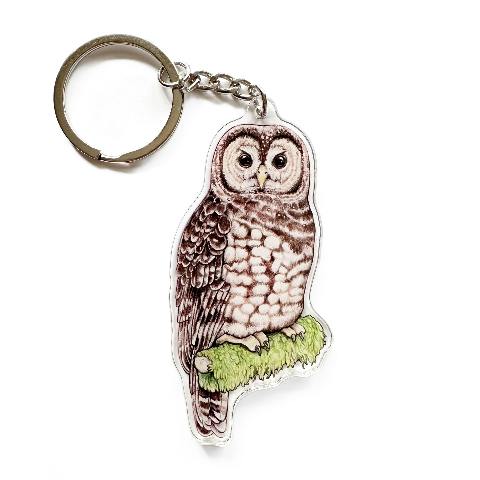 A keychain featuring an illustration of a spotted owl