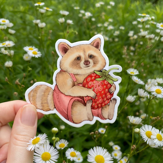 Sticker of a raccoon holding a strawberry held by a hand with a floral background