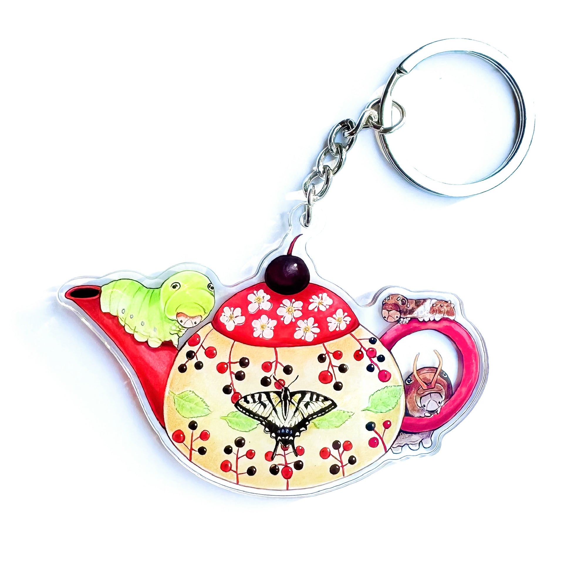 A double-sided acrylic keychain with a red teapot design, featuring illustrations of tiger swallowtail caterpillars and a butterfly on the front.