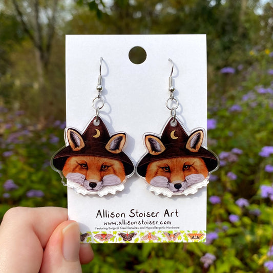 Wizard fox earrings on a card held by a hand with a natural background