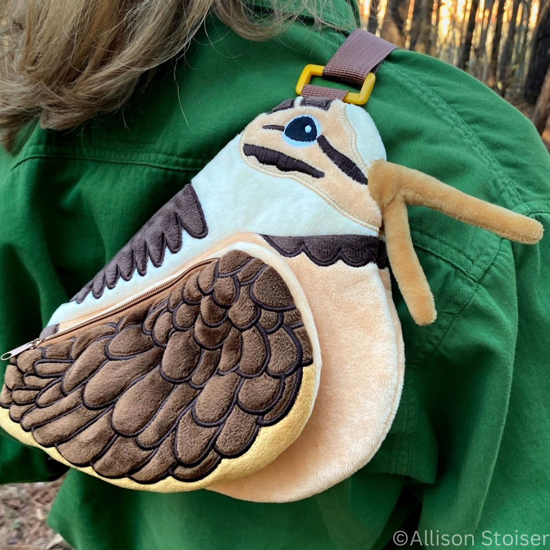 Plush woodcock-shaped bag worn on a person's shoulder.