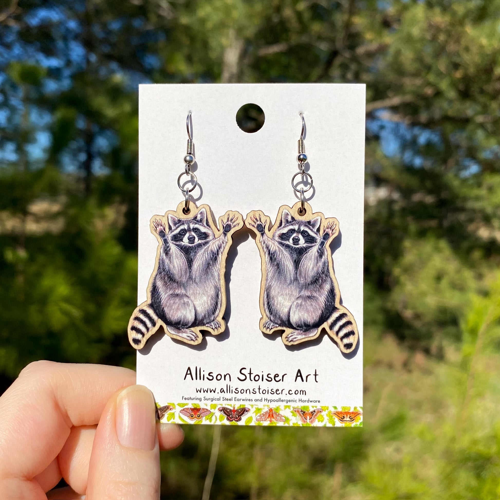 a pair of wooden raccoon earrings