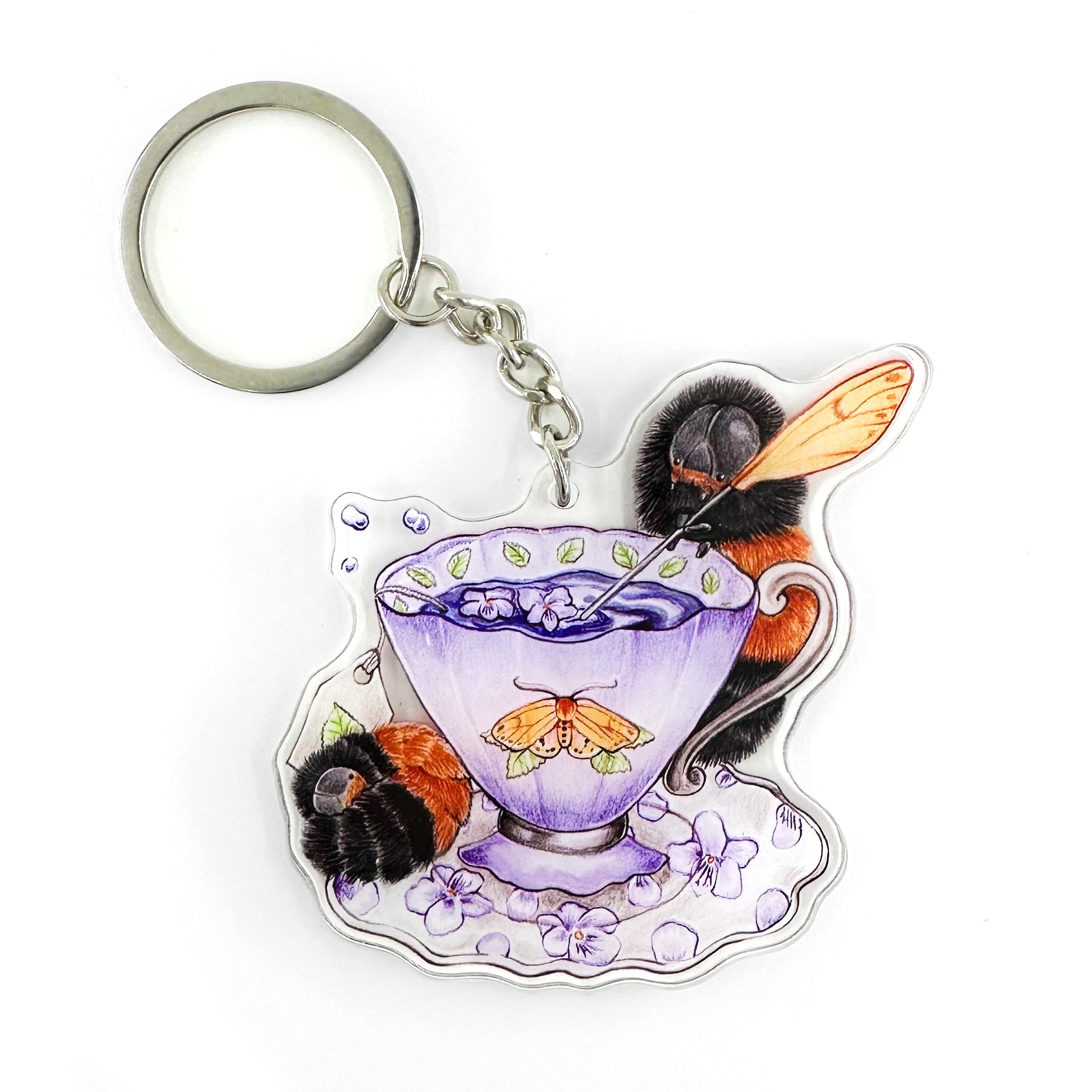 A keychain featuring an illustration of a wooly bear caterpillar tea party