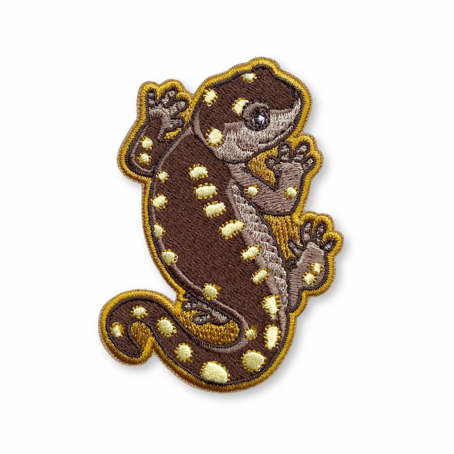 Embroidered patch of a yellow-spotted salamander on a white background