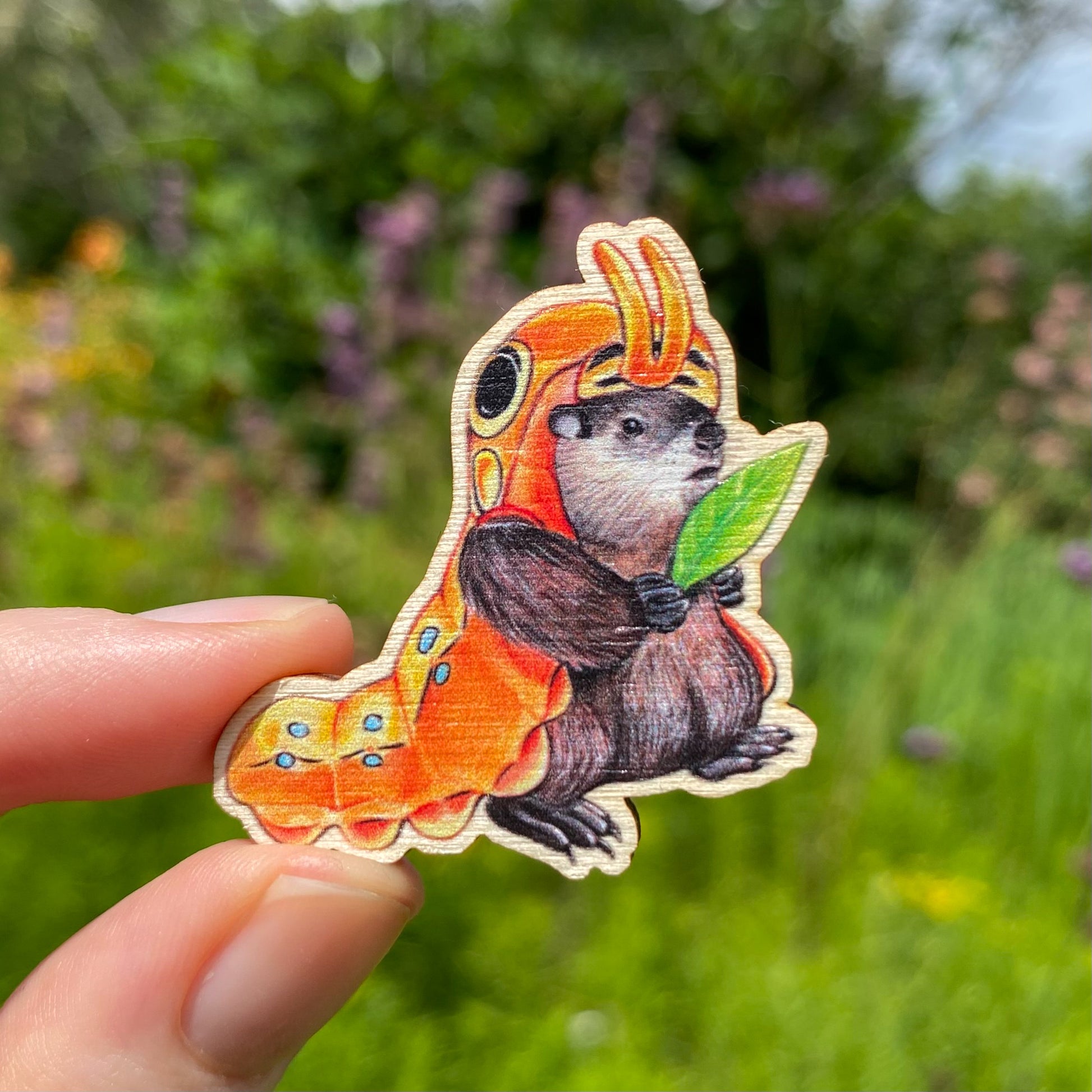 A sustainably sourced wooden pin featuring a groundhog dressed as a caterpillar