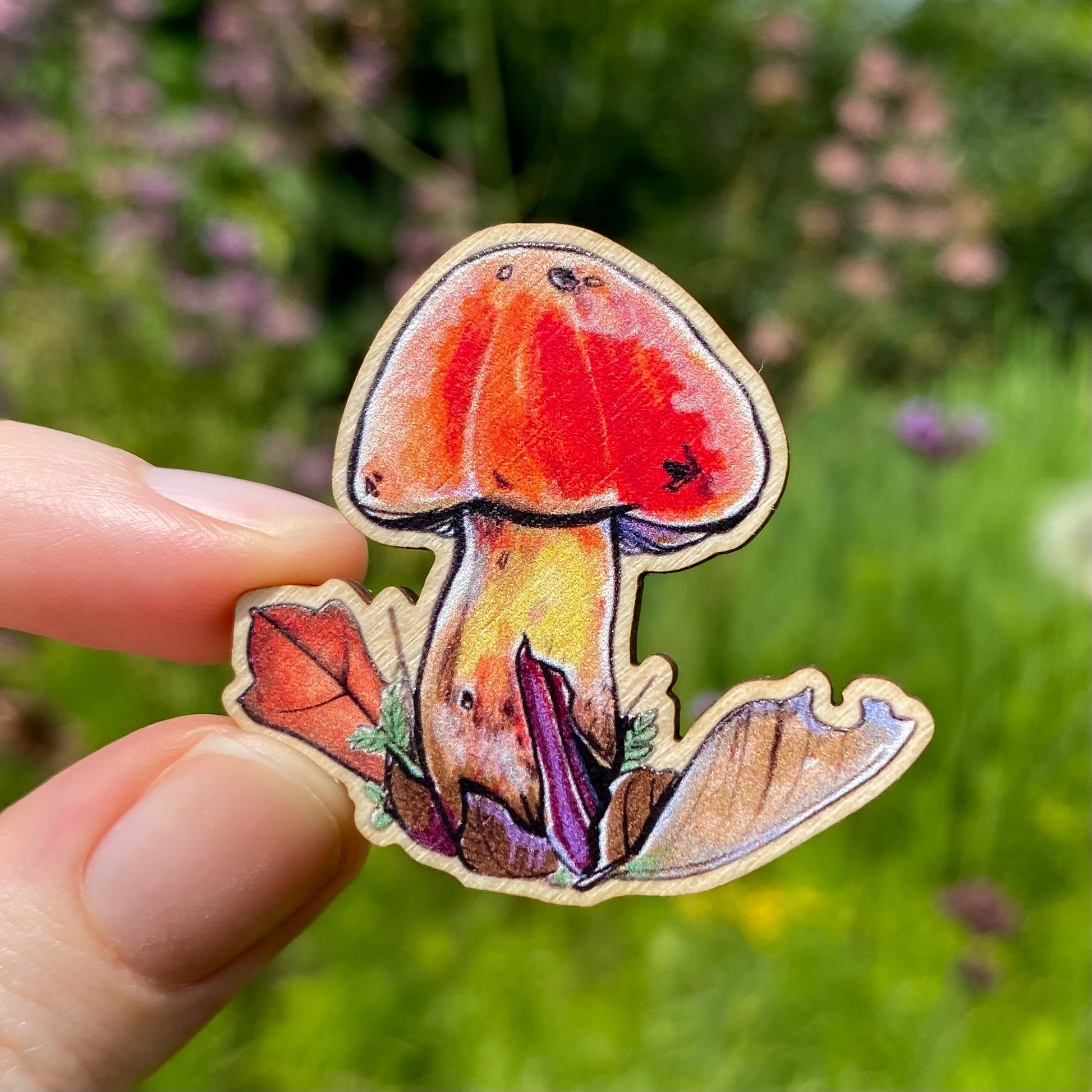 A sustainably sourced pin featuring an illustration of an orange bolete mushroom