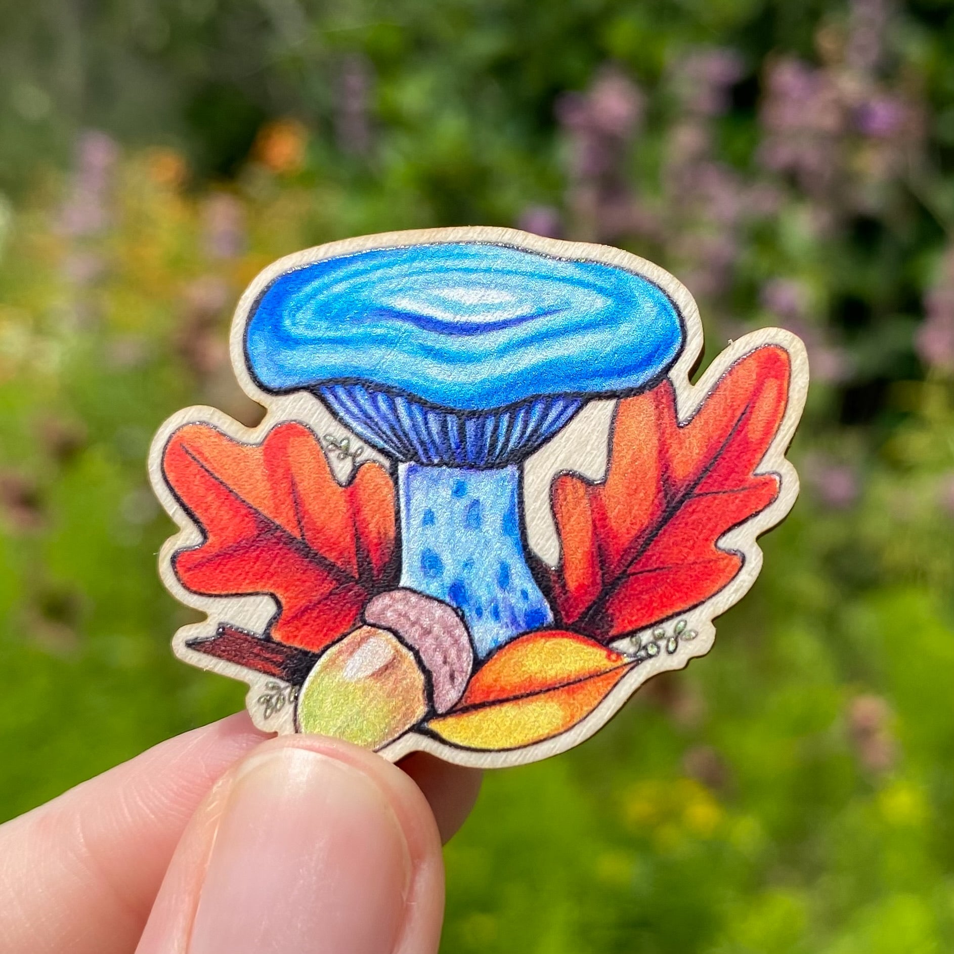 A sustainably sourced pin featuring an illustration of an indigo milkcap mushroom