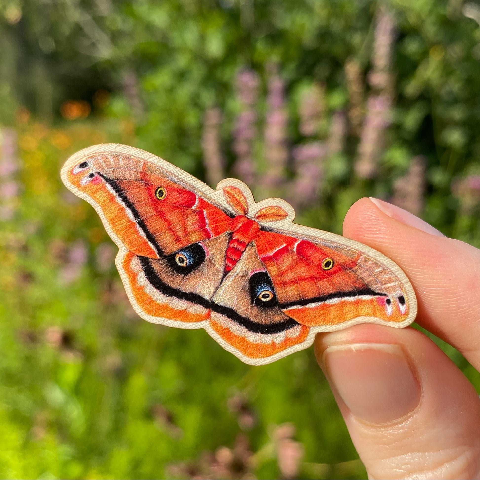 A sustainably sourced pin featuring an illustration of a Polyphemus moth