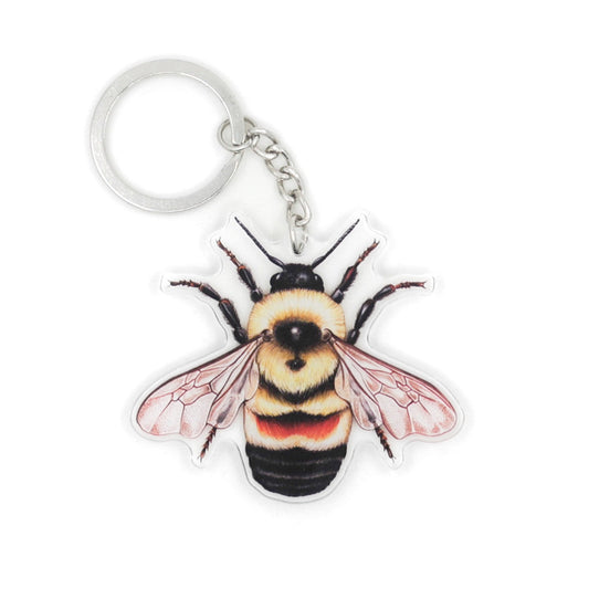 A keychain of a rusty-patched bumble bee on a white background.