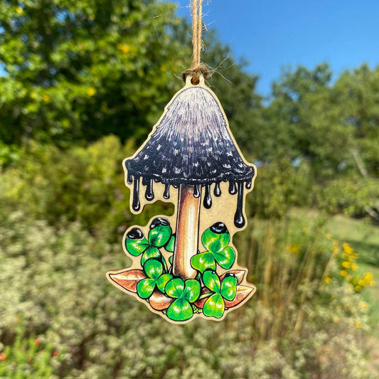 A wooden ornament strung with twine of a shaggy inkcap mushroom.