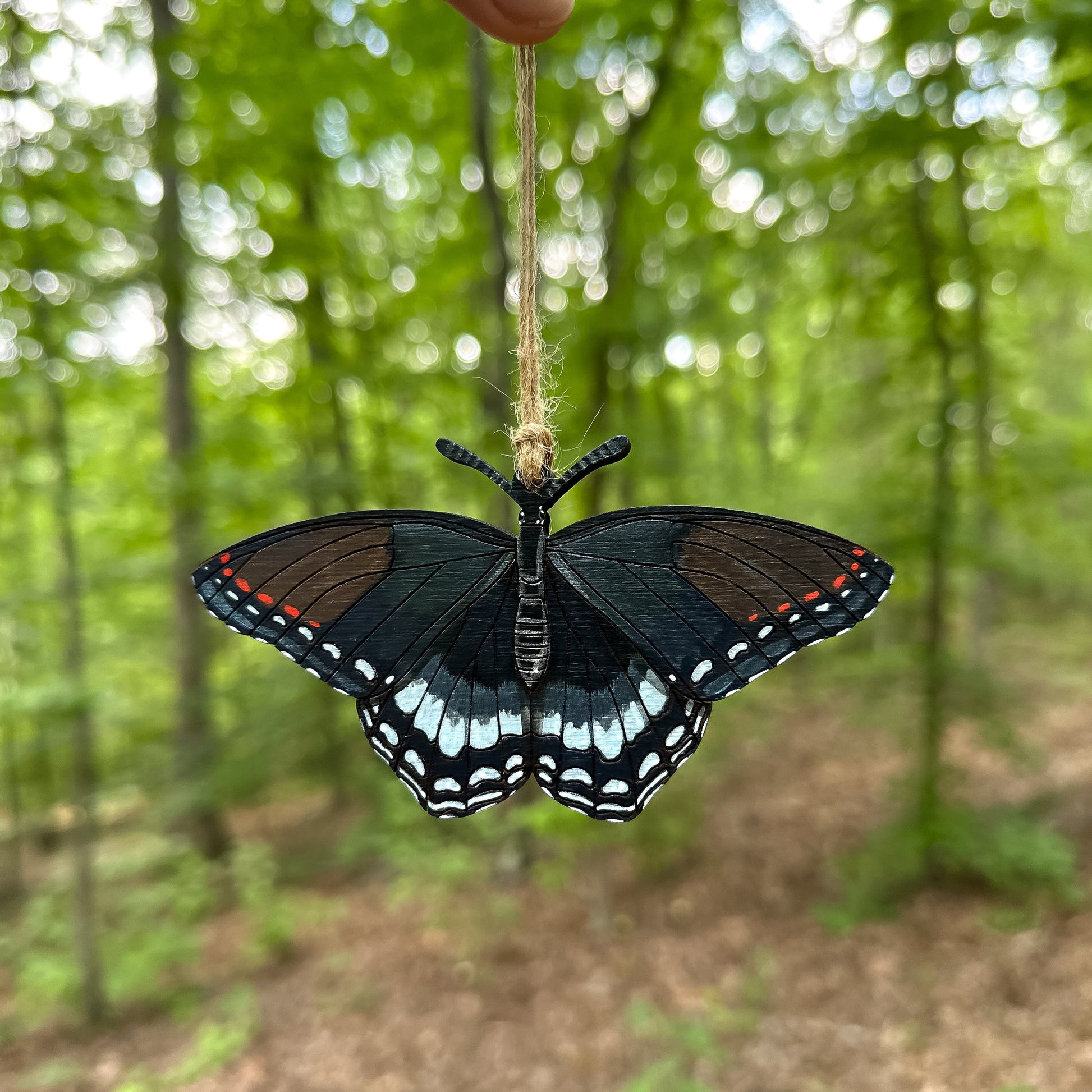 A hand-painted ornament of a red-spotted purple