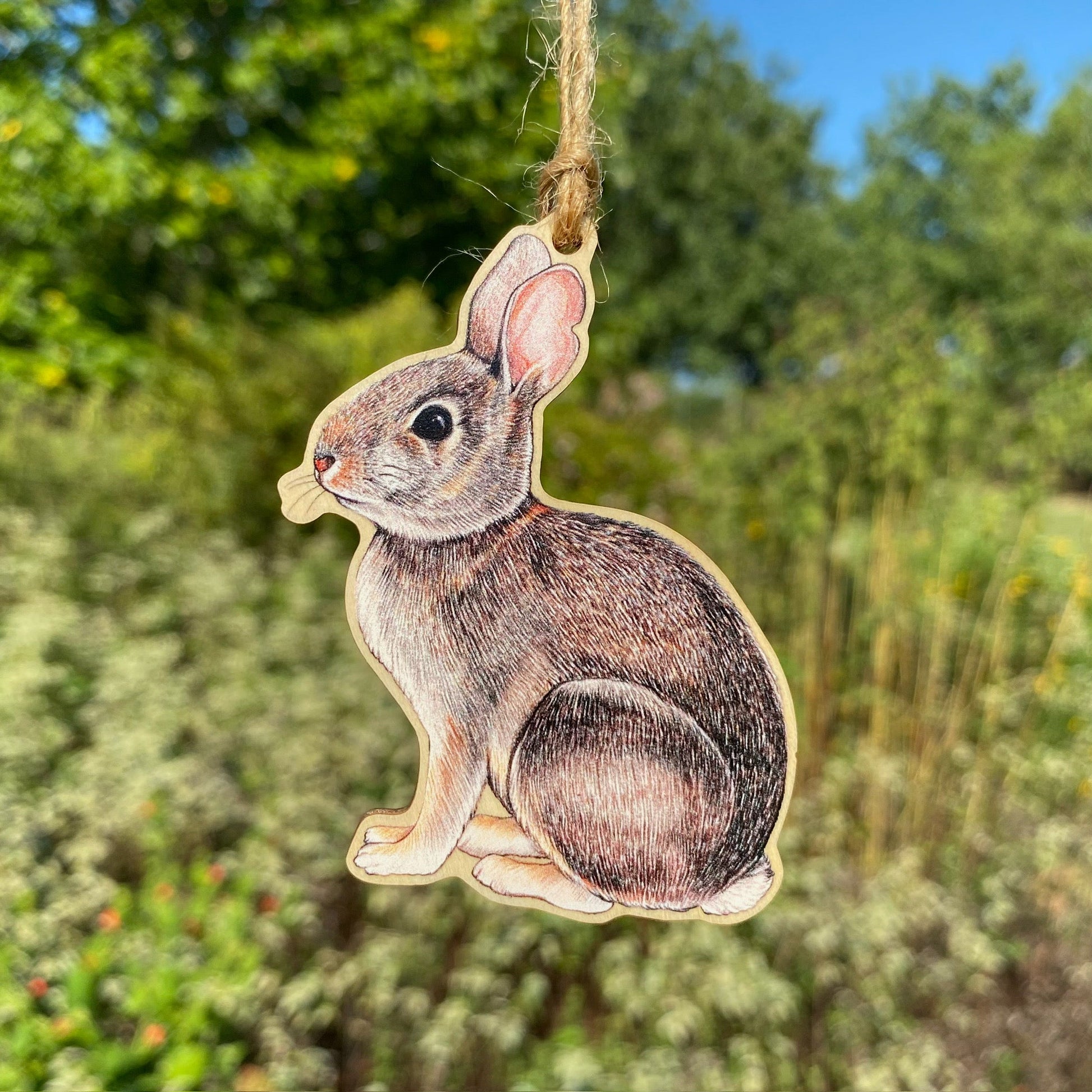 A wooden ornament strung with twine of an eastern cottontail rabbit.