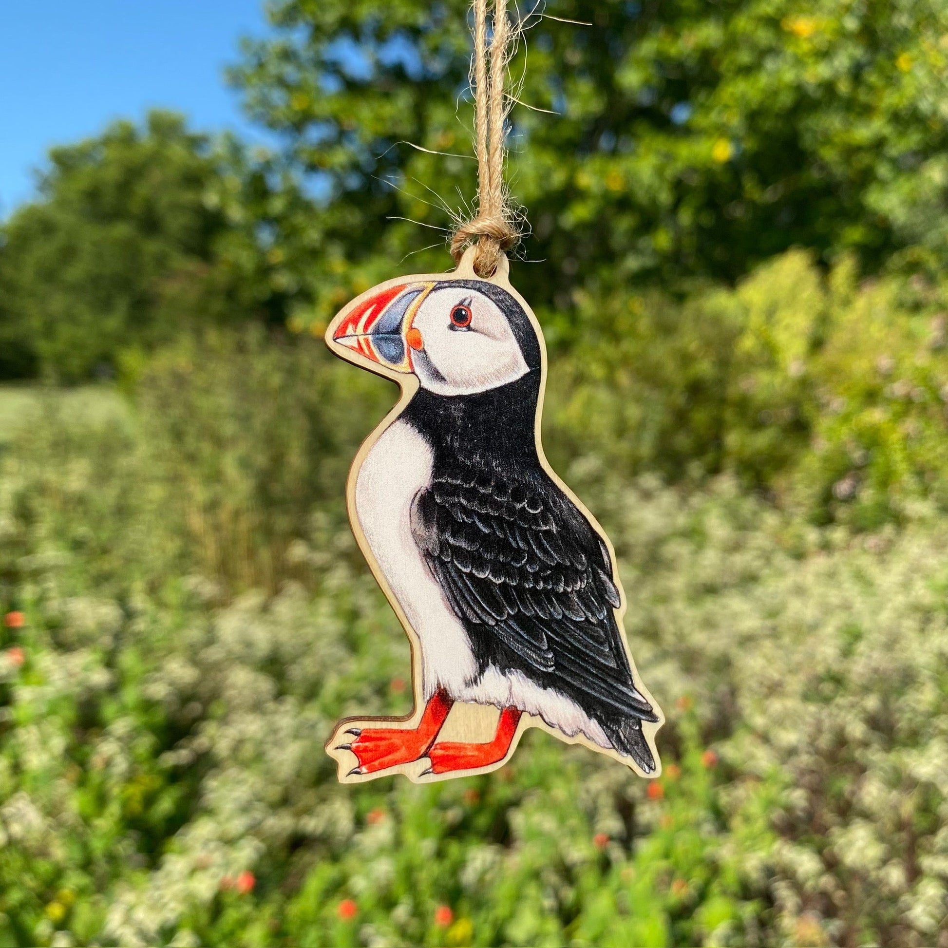 A wooden ornament strung with twine of an Atlantic puffin.