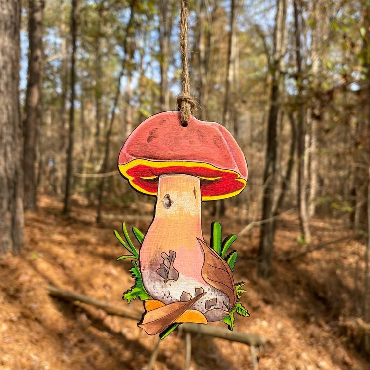 A hand-painted ornament of a large red bolete mushroom