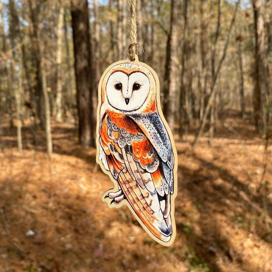 A wood print ornament featuring an illustration of a barn owl