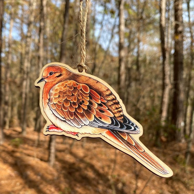 A wood print ornament featuring an illustration of a mourning dove