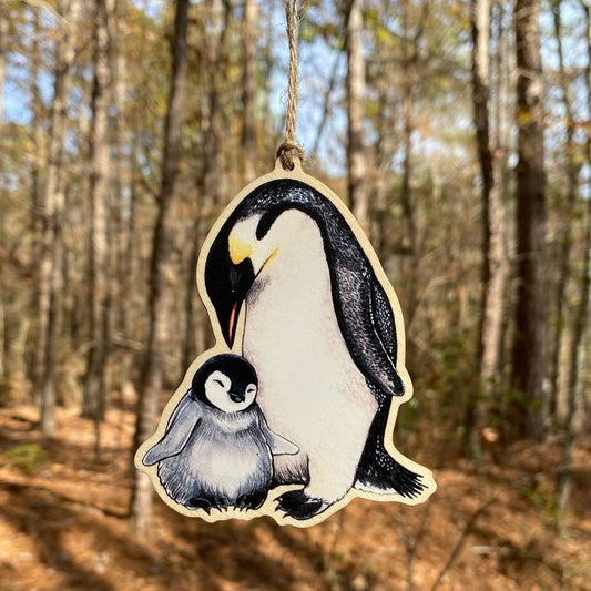 A wood print ornament featuring an illustration of an emperor penguin and chick