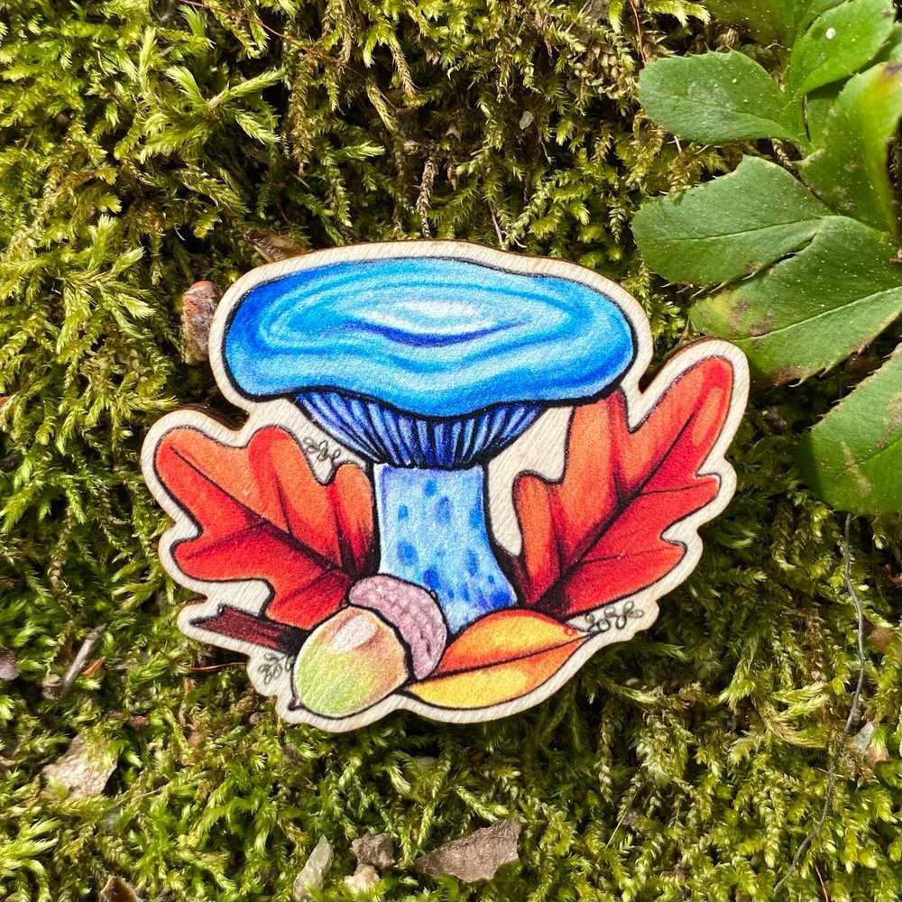 A sustainably sourced pin featuring an illustration of an indigo milkcap mushroom