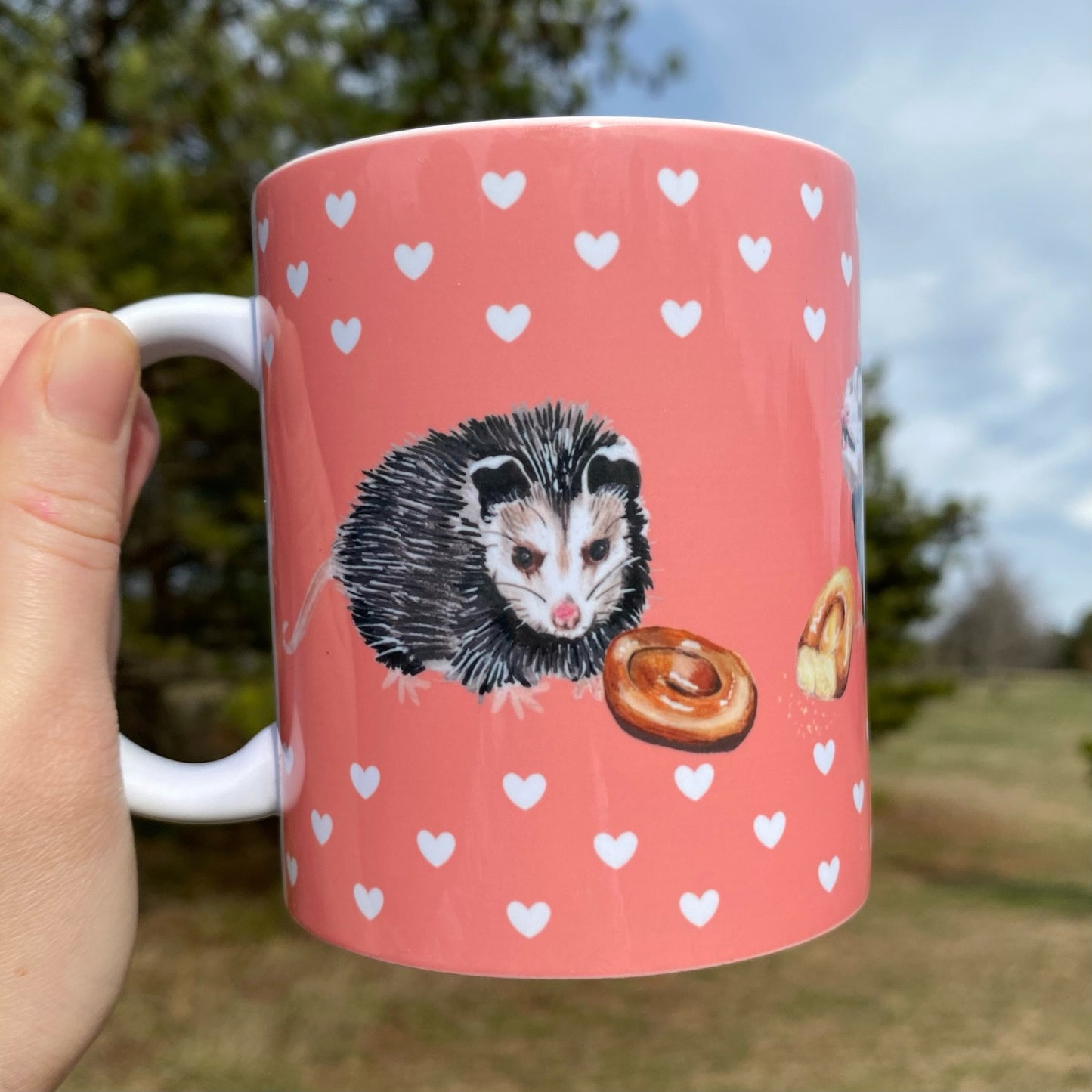 A mug featuring opossums and honeybuns