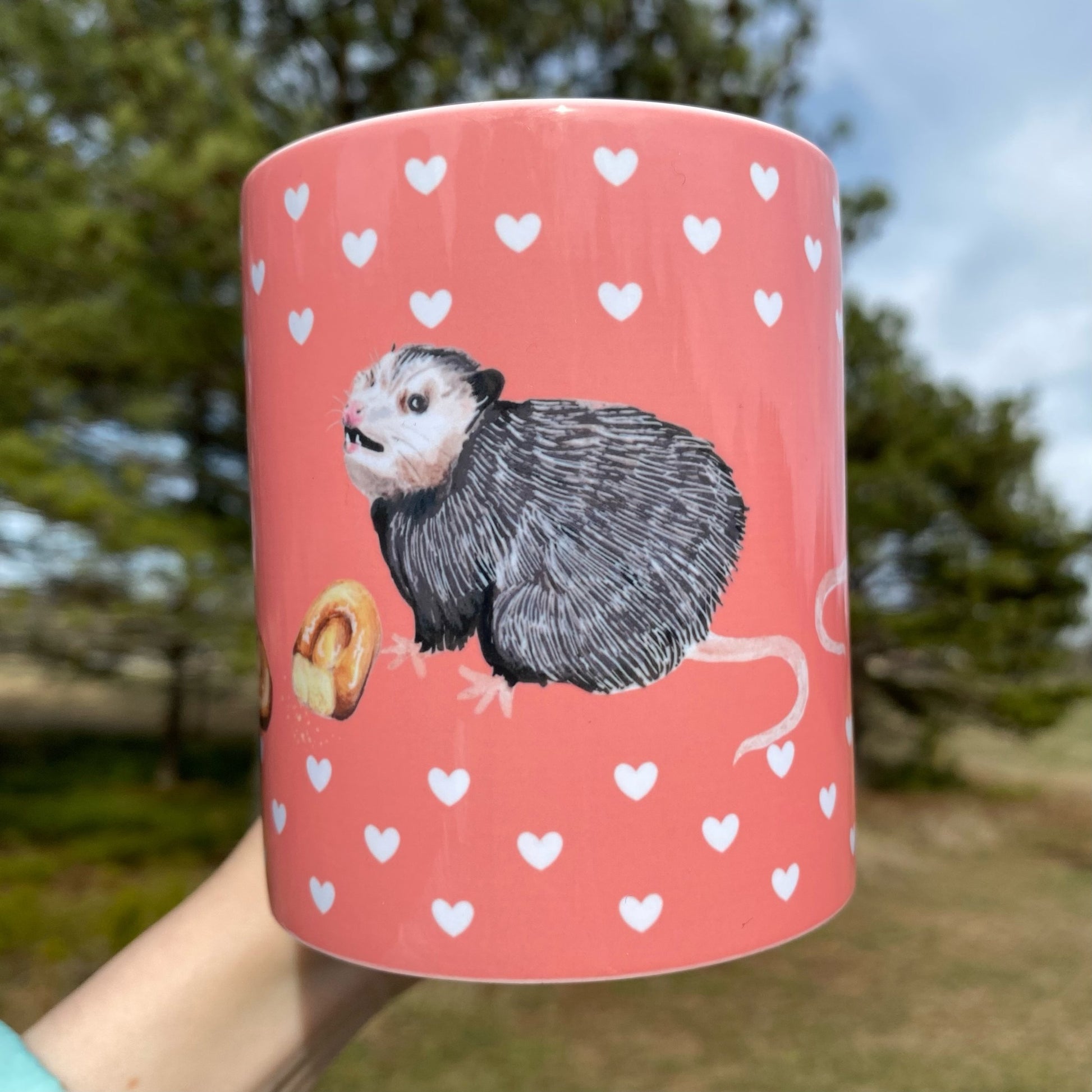 A mug featuring opossums and honeybuns