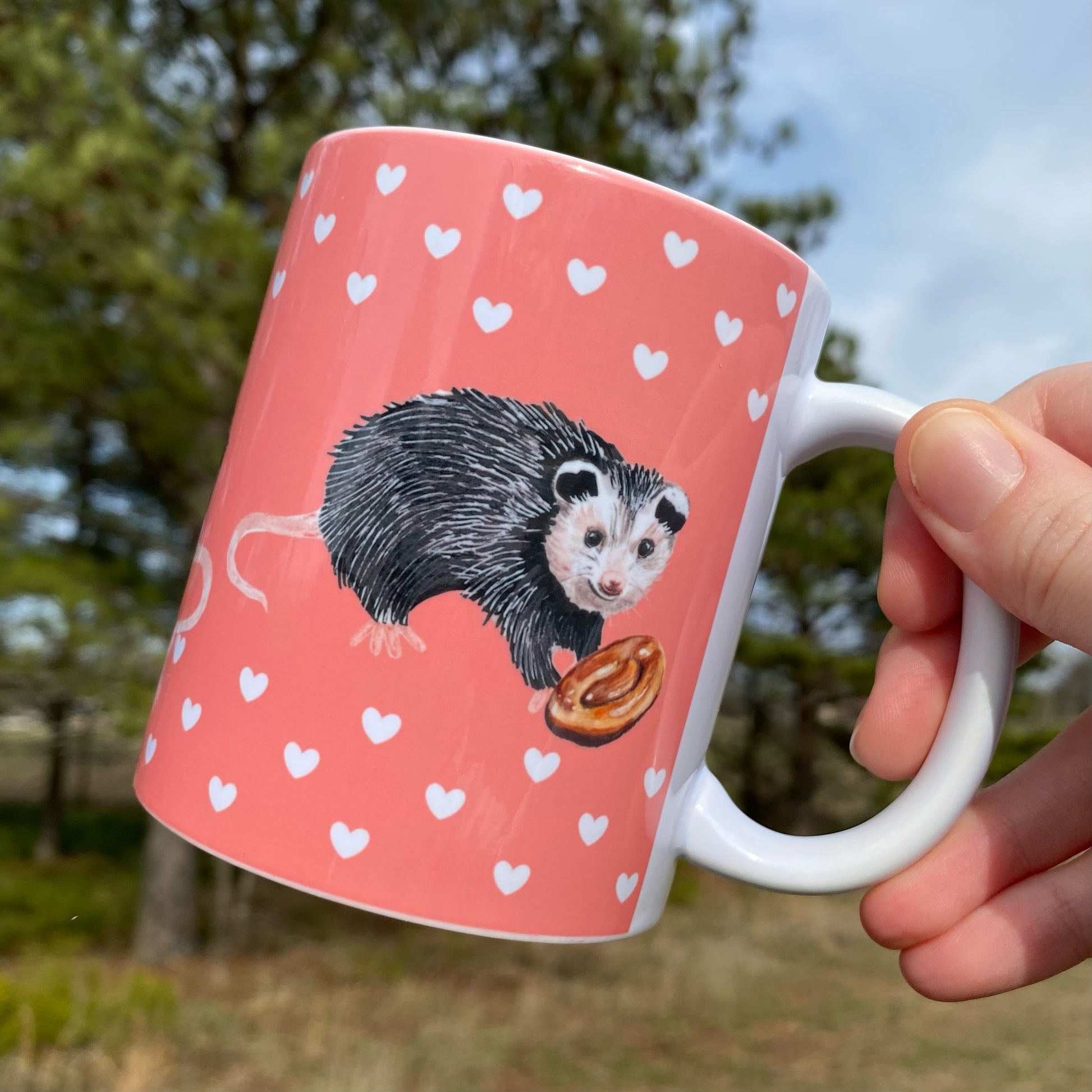 A mug featuring opossums and honeybuns