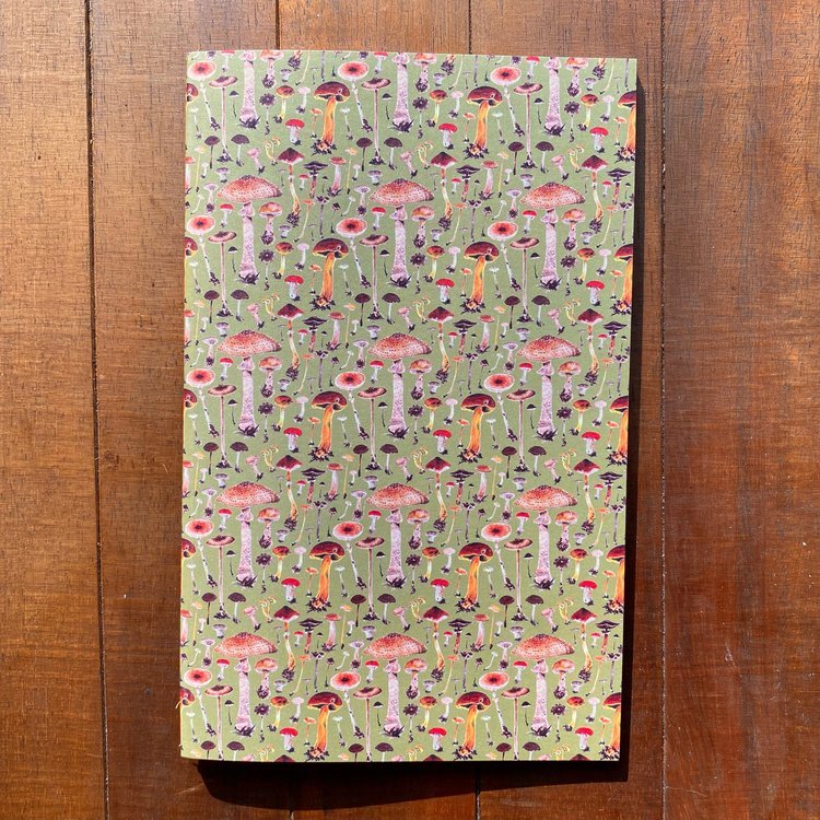 A handmade notebook featuring watercolor mushrooms on an olive green background